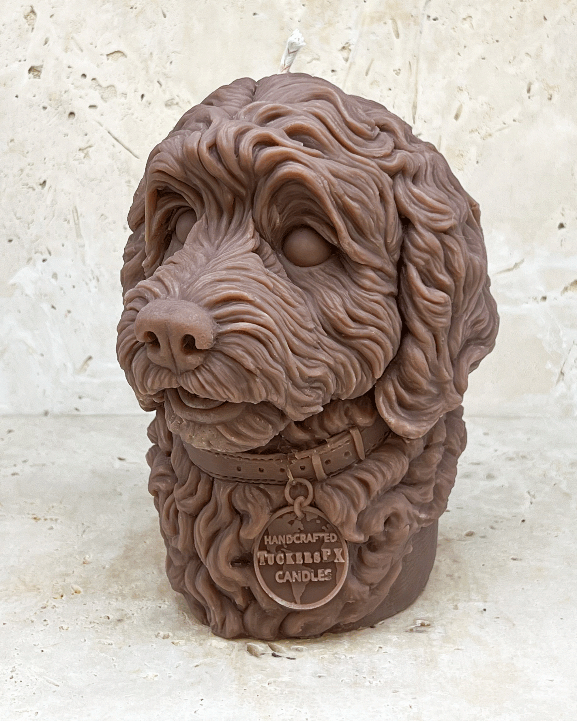 A brown Cockerpoo dog head moulded candle side view