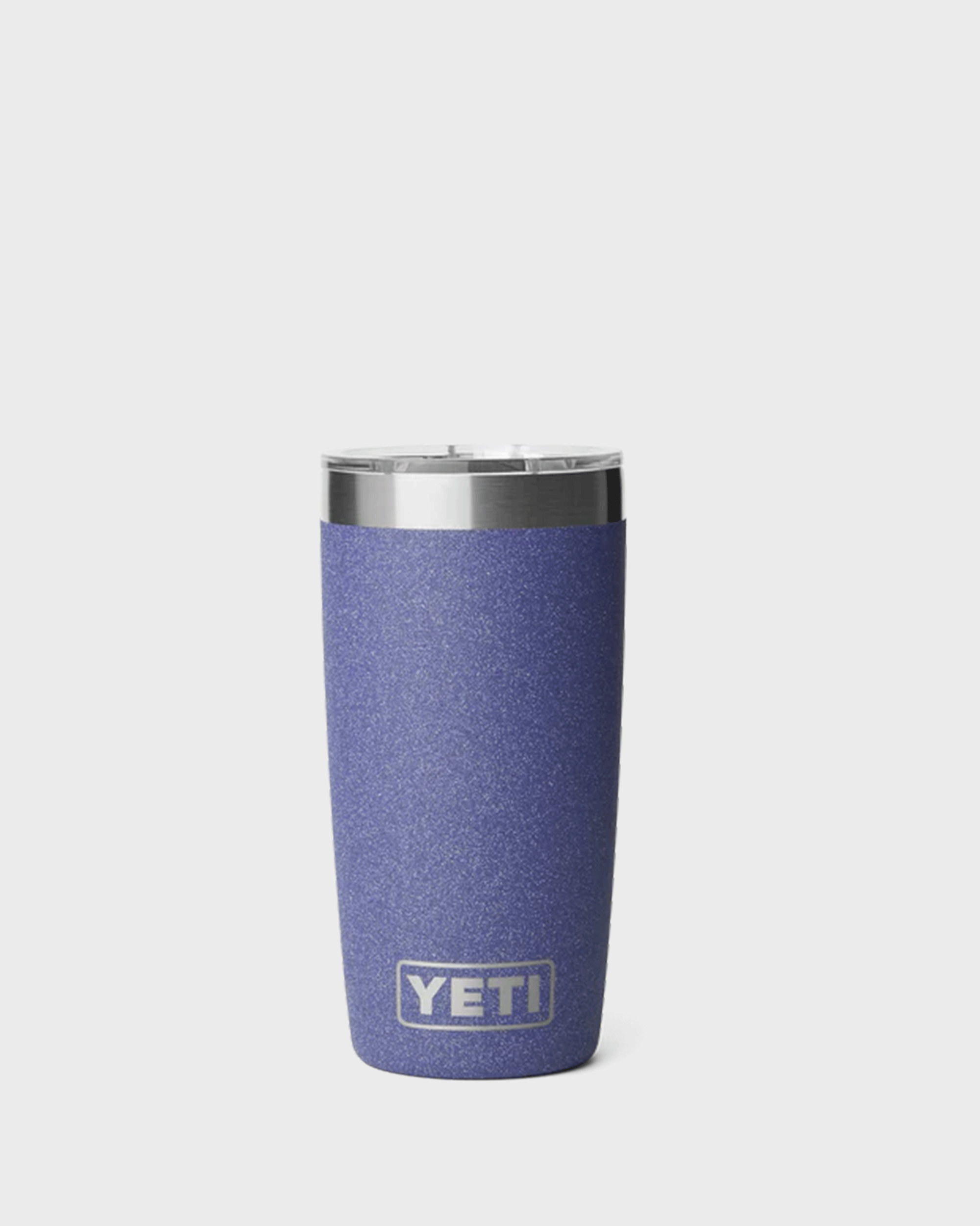 A blue-purple glitter-finish called Moondust insulated tumbler with a clear lid and stainless steel rim, standing upright against a light grey background. The tumbler features the YETI logo near the bottom and has a tapered shape that narrows toward the base.