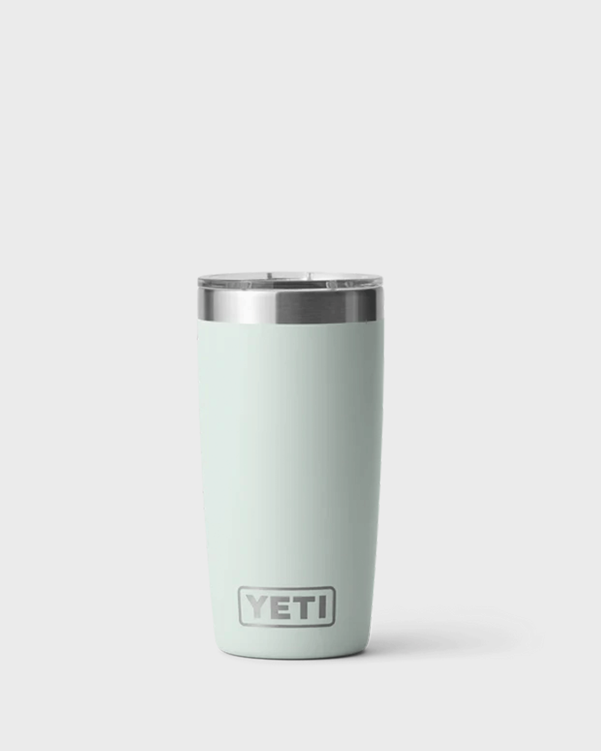 A pale minty green insulated tumbler with a clear lid and stainless steel rim, standing upright against a light grey background. The Ridgeline coloured tumbler features the YETI logo near the bottom and has a tapered shape that narrows toward the base.