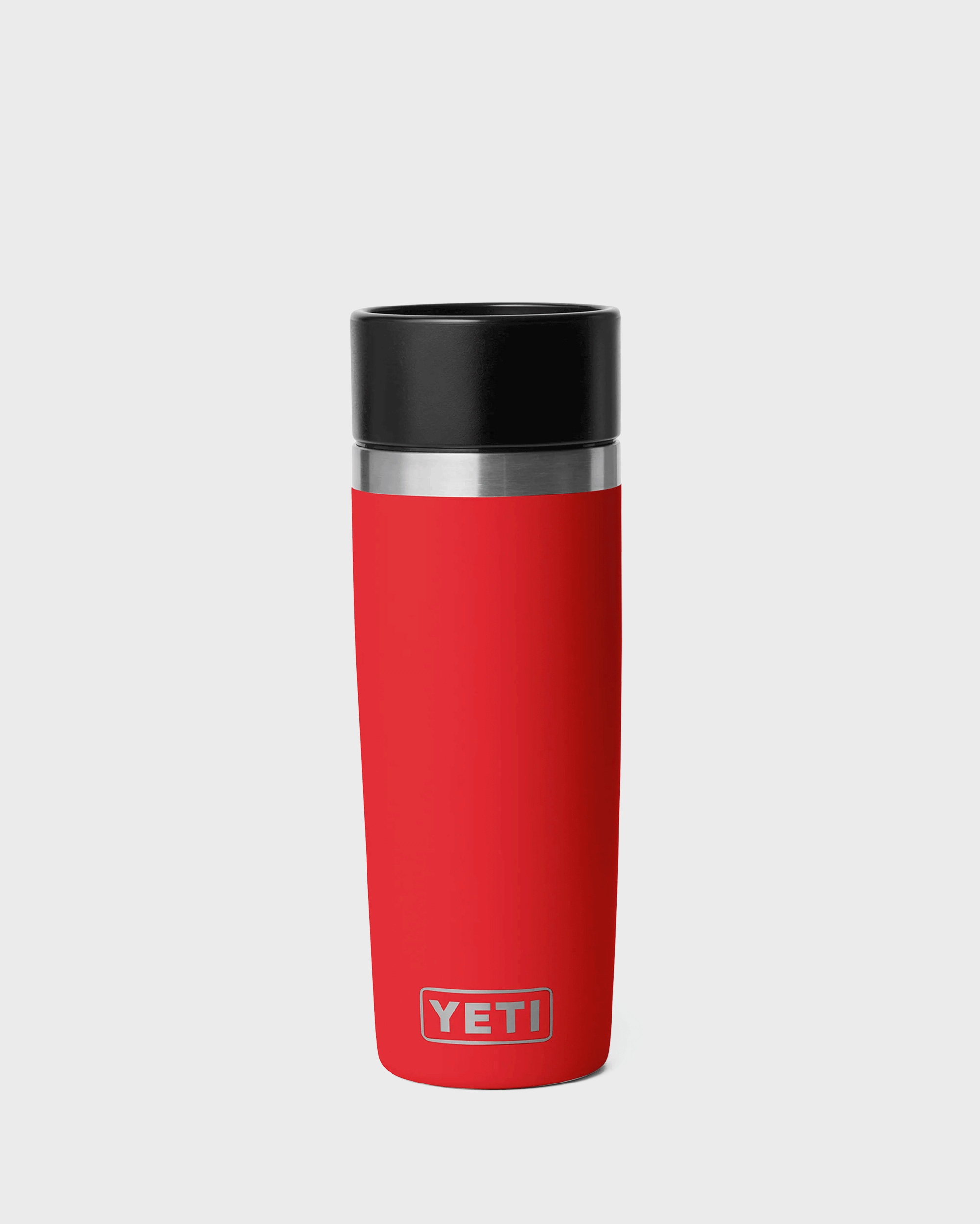 A red YETI travel tumbler with a black lid and a silver metallic band, shown on a light gray background.