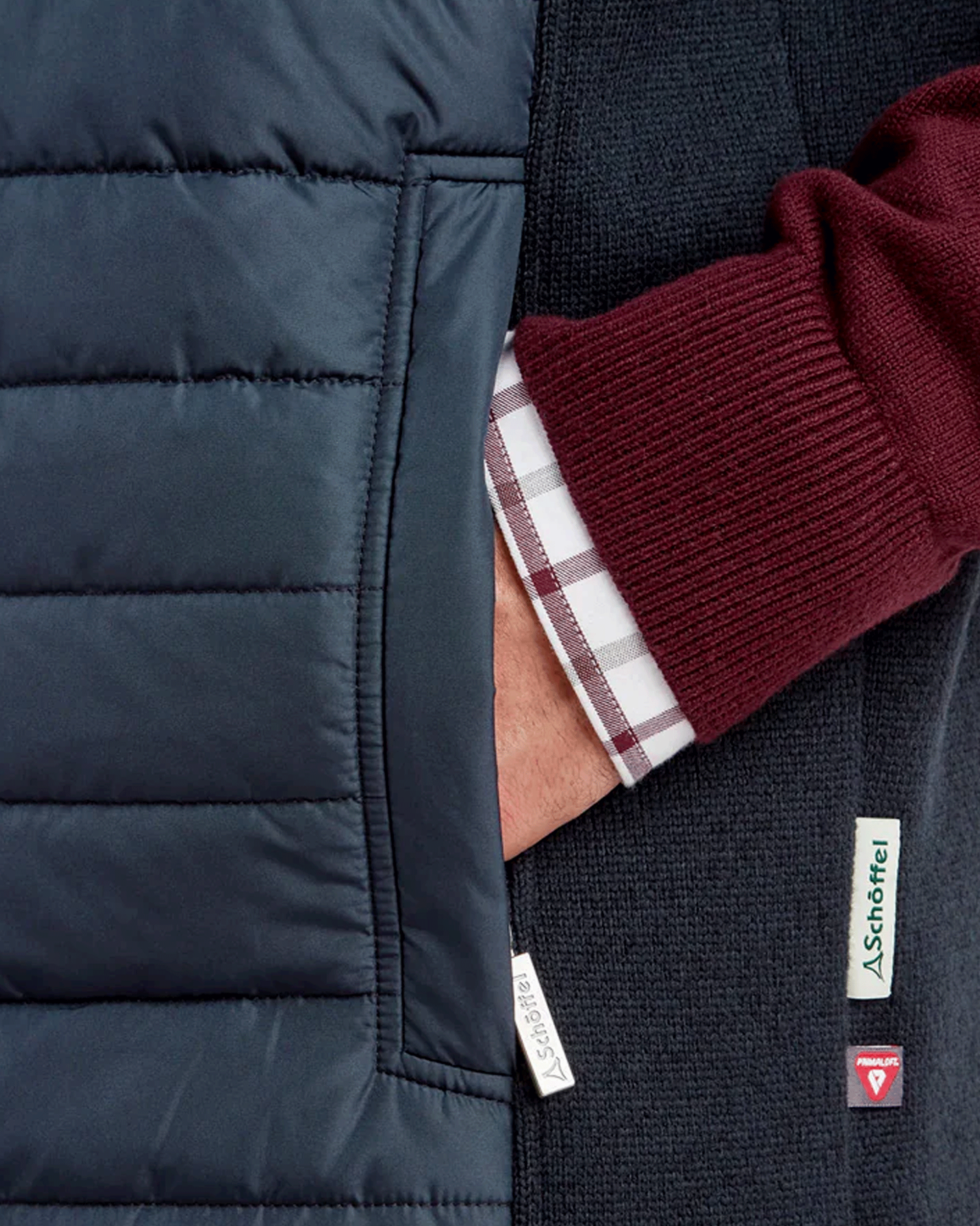 Close-up of a man's wrist with his hand in the pocket of a navy Schöffel Oakham Hybrid Gilet.