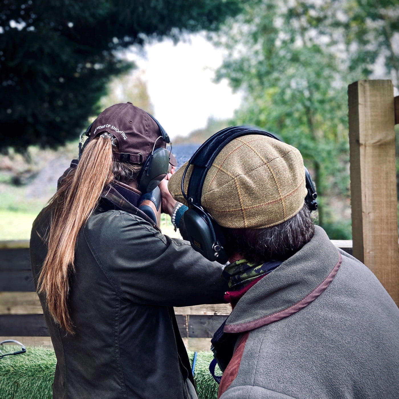 Two people in outdoor setting with one holding a gun.